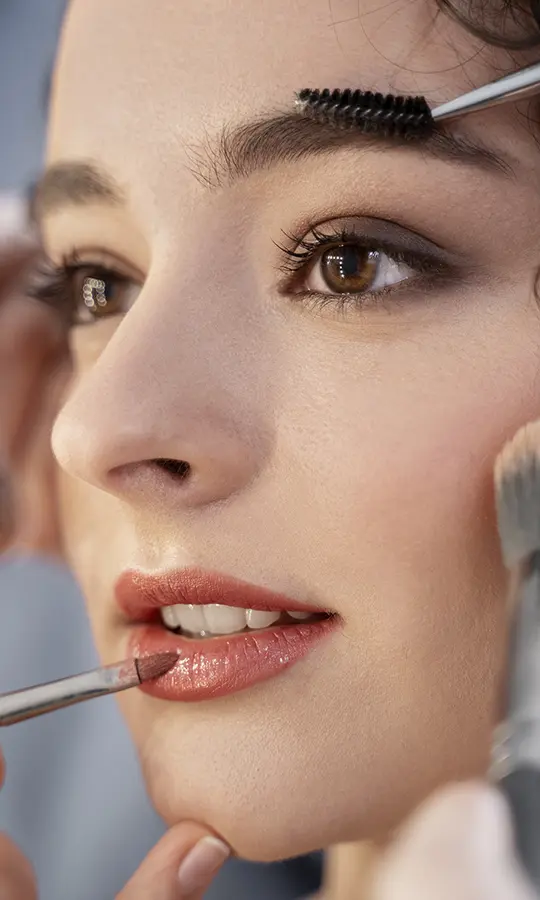 a woman applying makeup on her lips